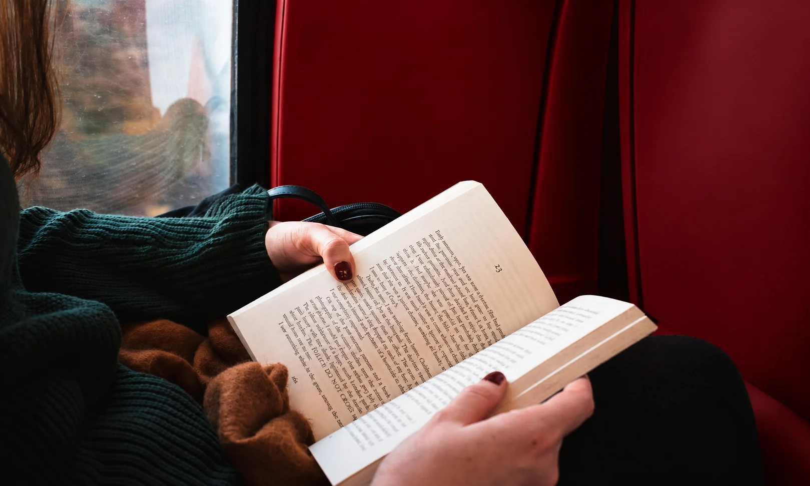 Person reading a book quietly indoors