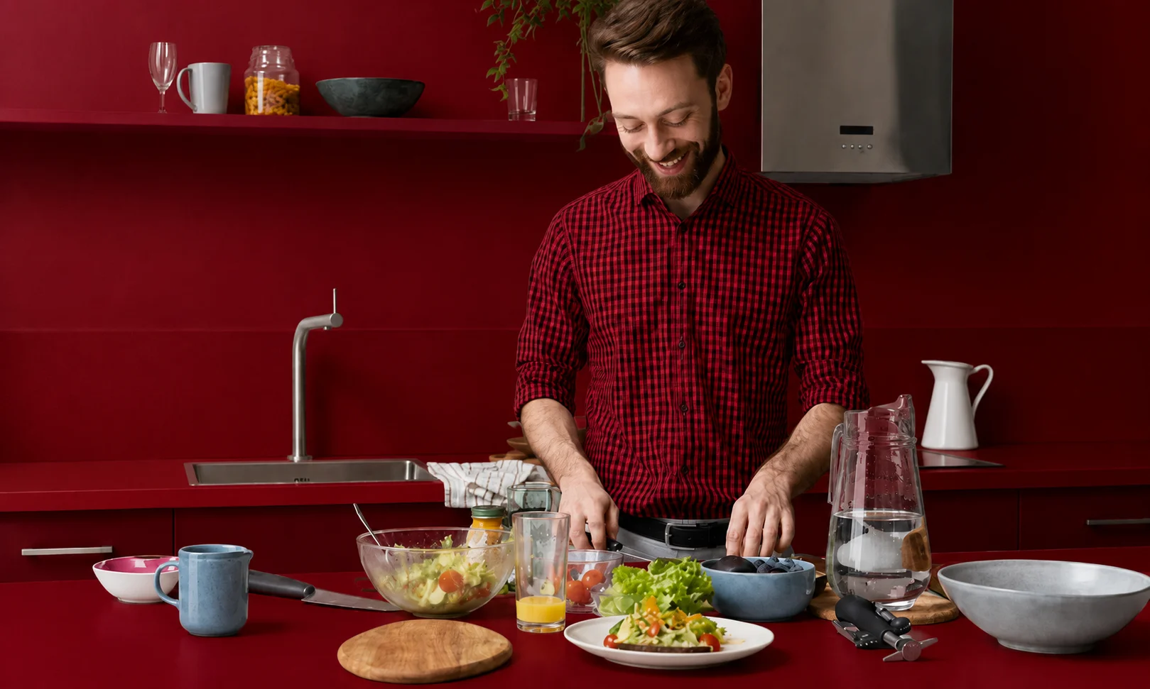 Chef preparing a culinary dish in a modern kitchen setup with dark red accents