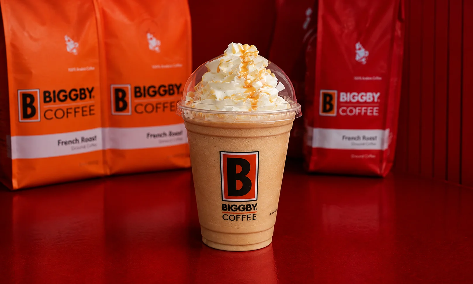 A BIGGBY COFFEE cup displayed in a bright retail environment.