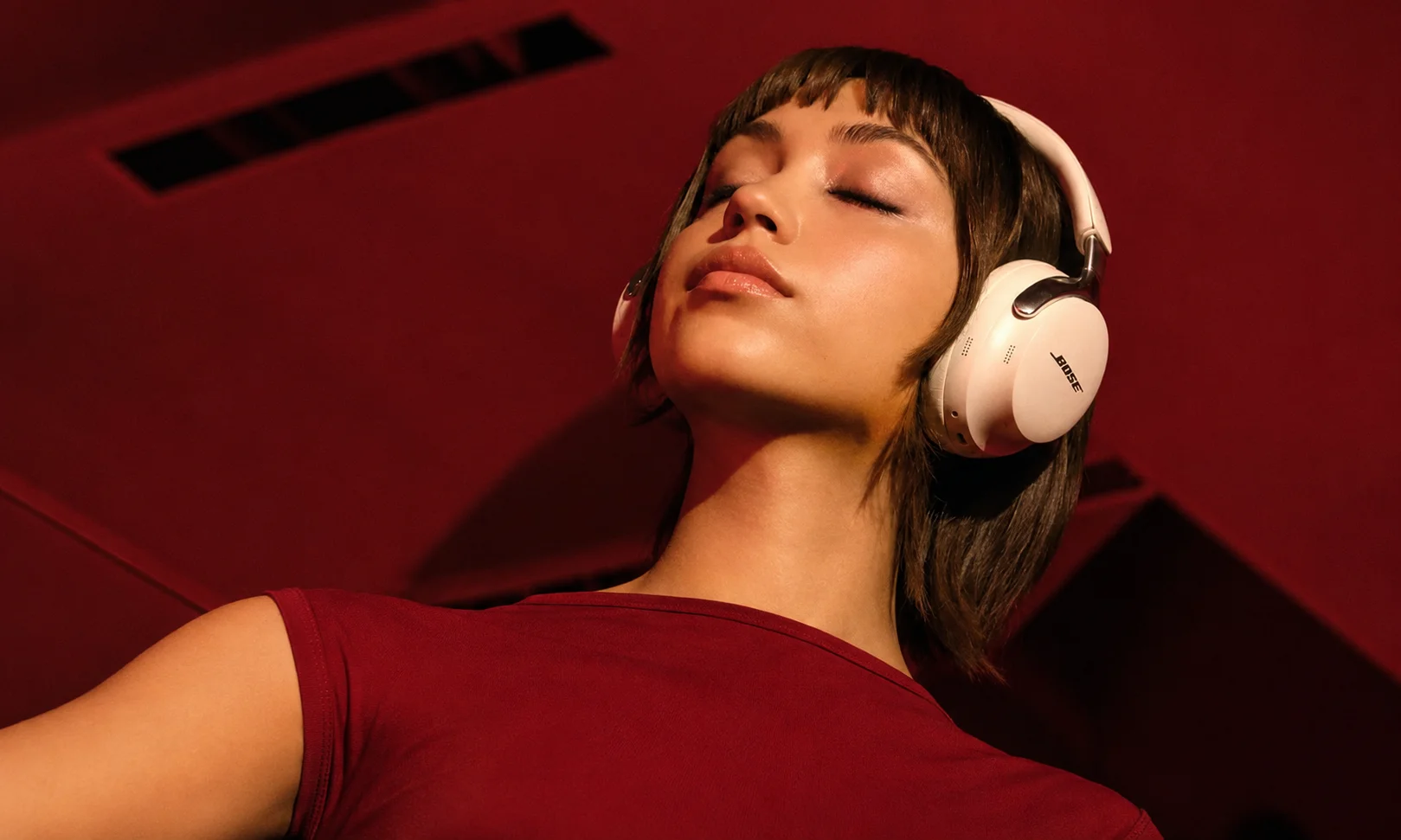 A close-up of a person wearing Bose QuietComfort Ultra headphones.