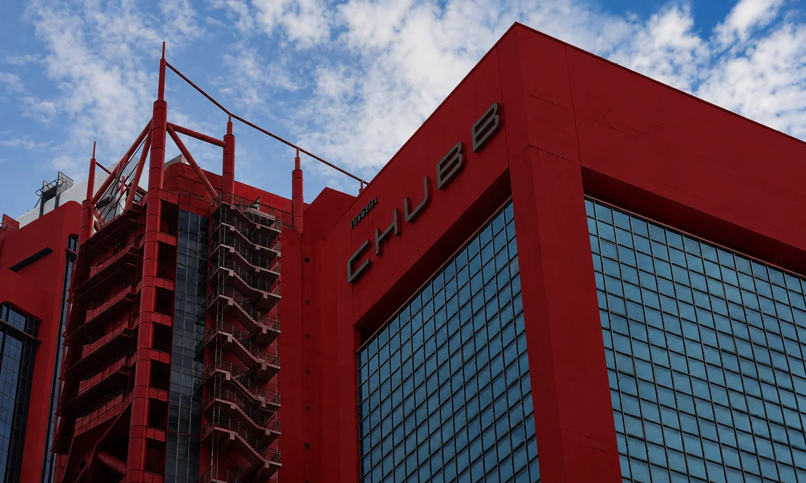 | Best Insurance Companies in the World in 2026 The Chubb corporate name on a tall red commercial building with glass grid windows.