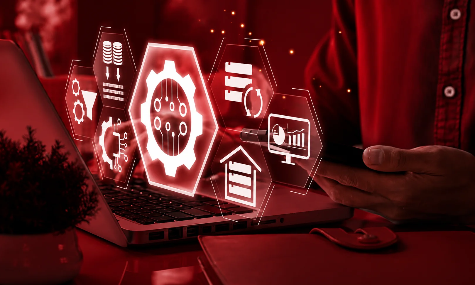 person using a laptop with glowing red data workflow and integration icons floating above