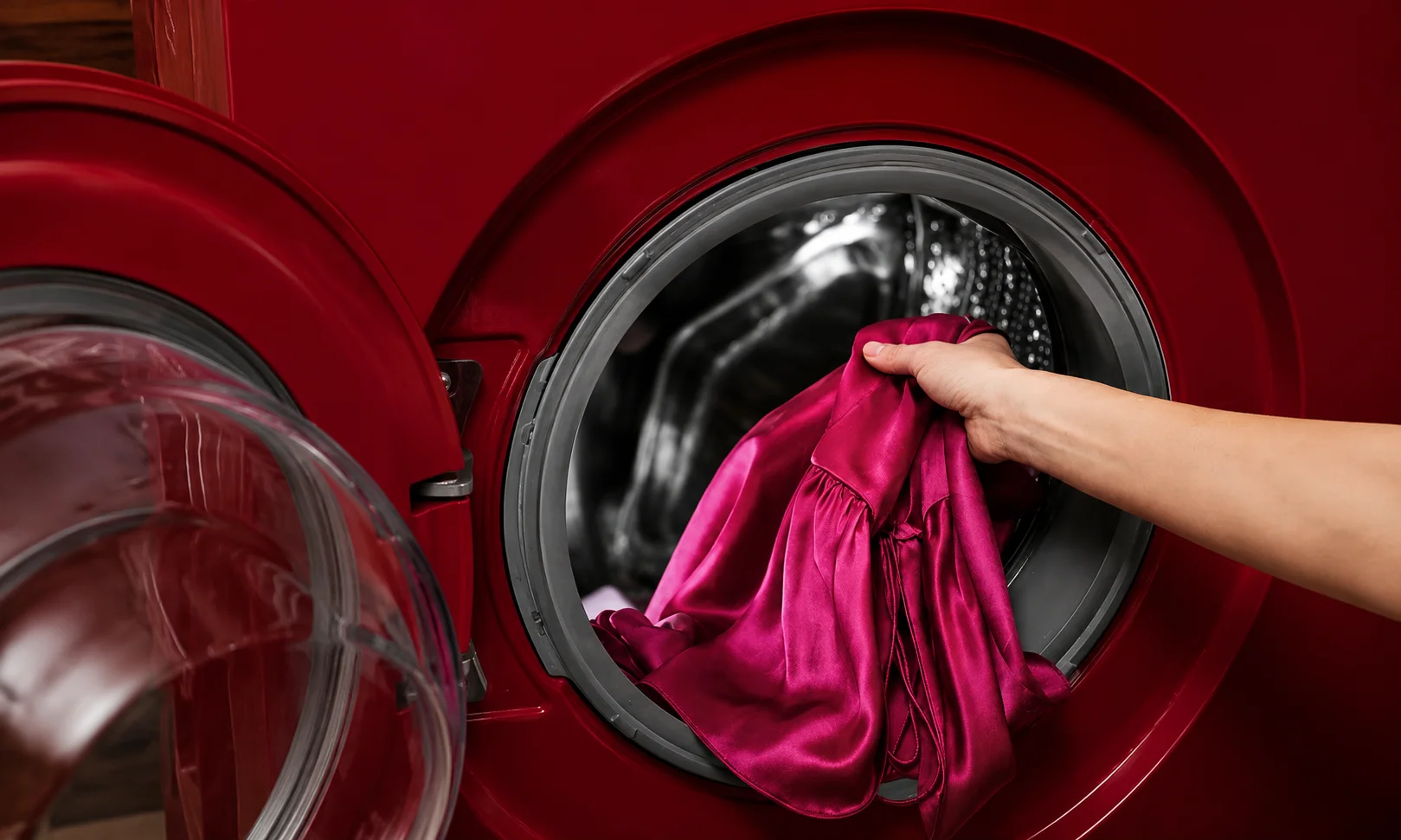 | Dupatta: Global Styling, History, Fabrics and Care Guide A hand placing a delicate garment into a red washing machine for proper fabric care