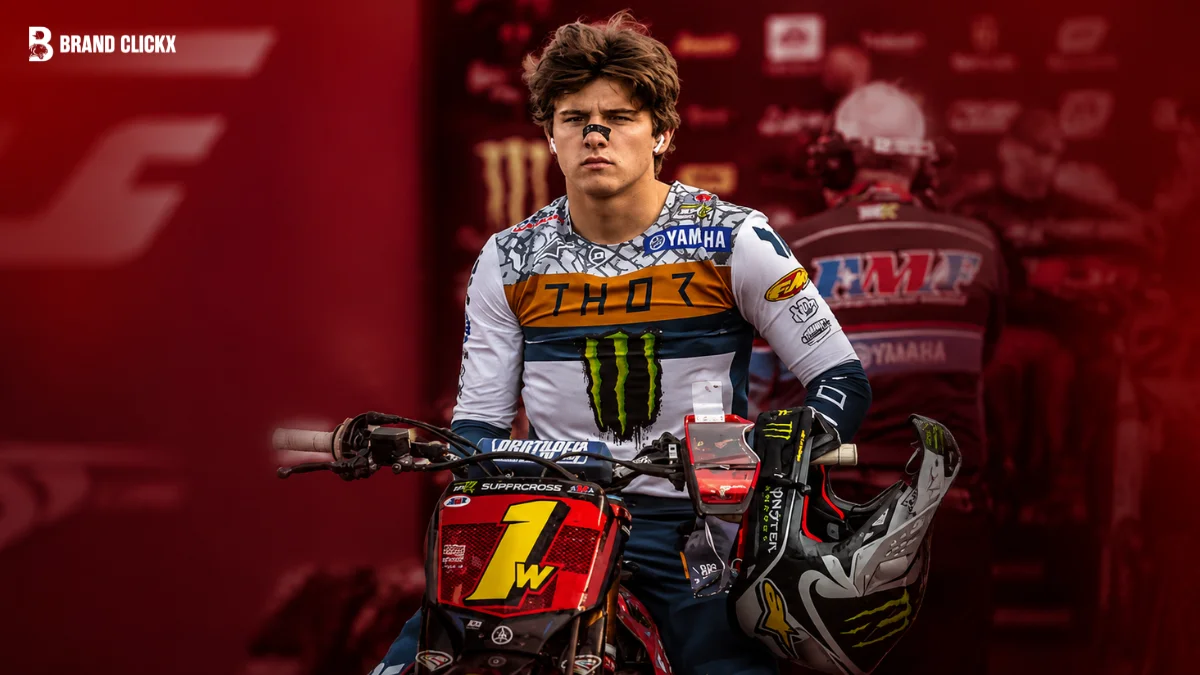 Portrait of Haiden Deegan posed with motocross gear set against a rich red studio backdrop.