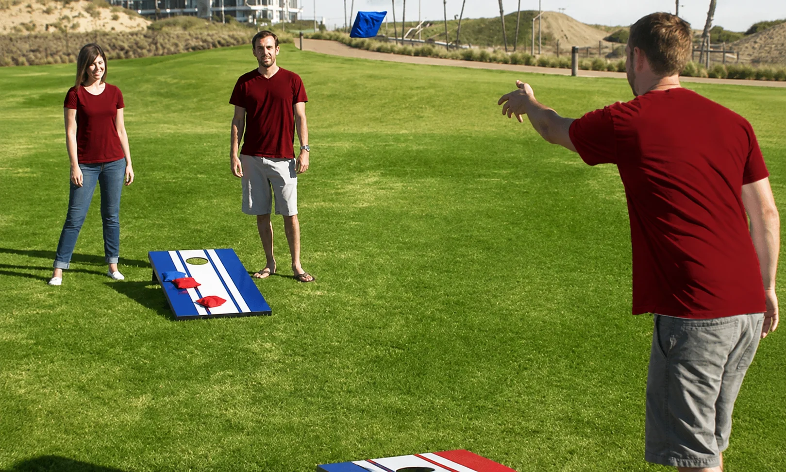 Cornhole bag sliding into the hole on a wooden cornhole board to score 3 points.