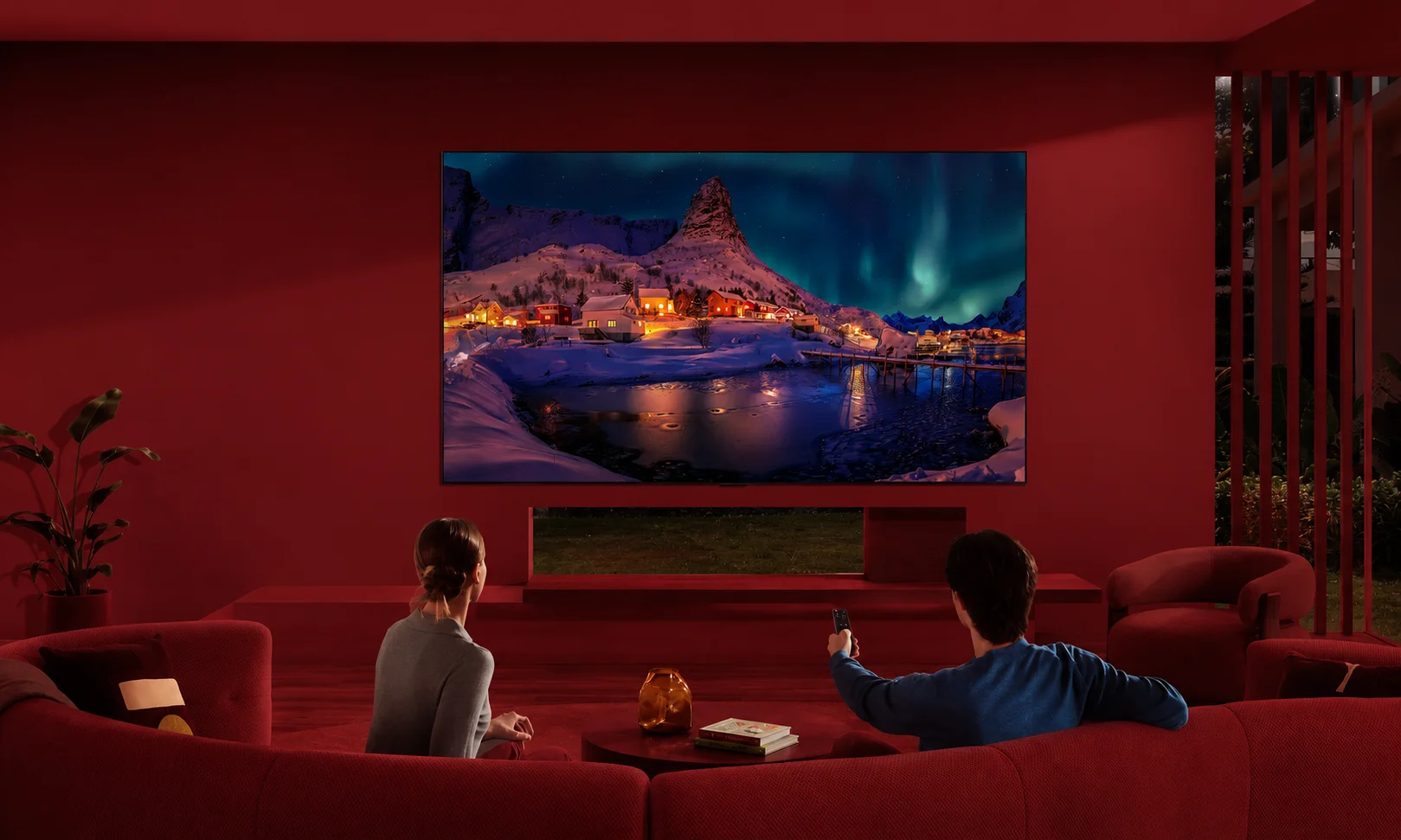 An LG G6 OLED TV mounted on a wall within a red-themed room.