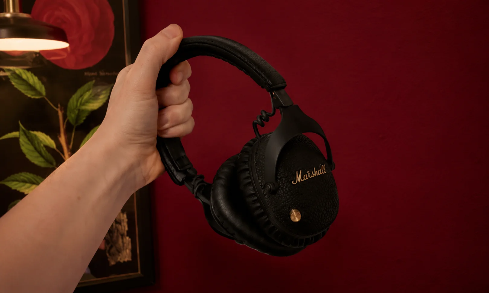 Marshall headphones being held up in a studio setting.