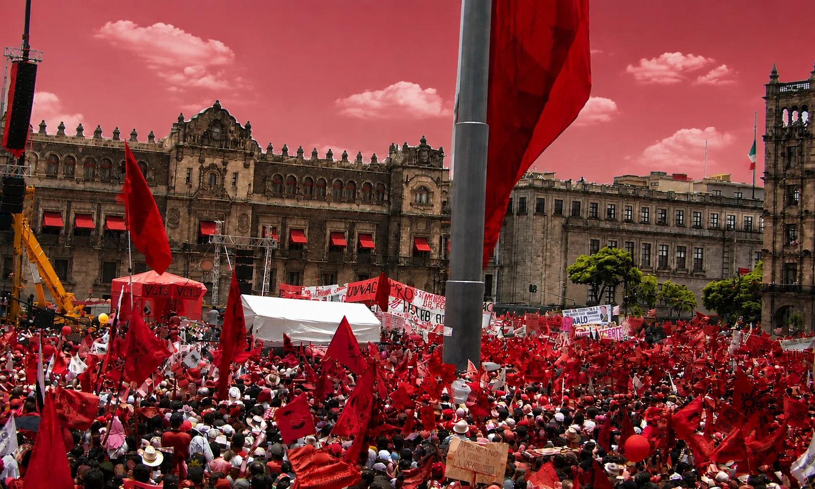 A crowd gathered in a public square or stadium in Mexico City set against a dark red ambient backdrop.