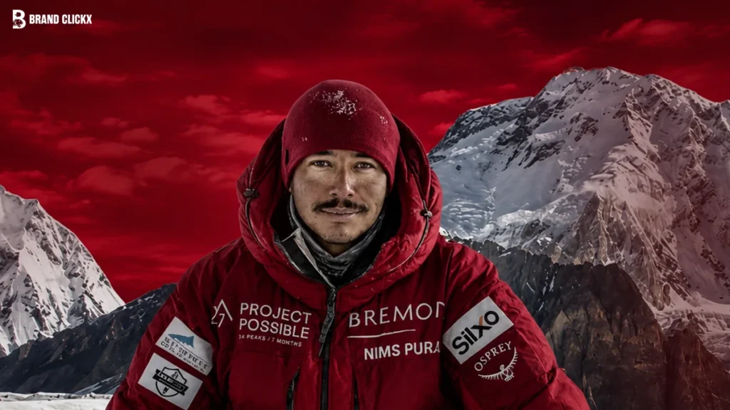 Mountaineer in red parka standing before snowy peaks and red sky