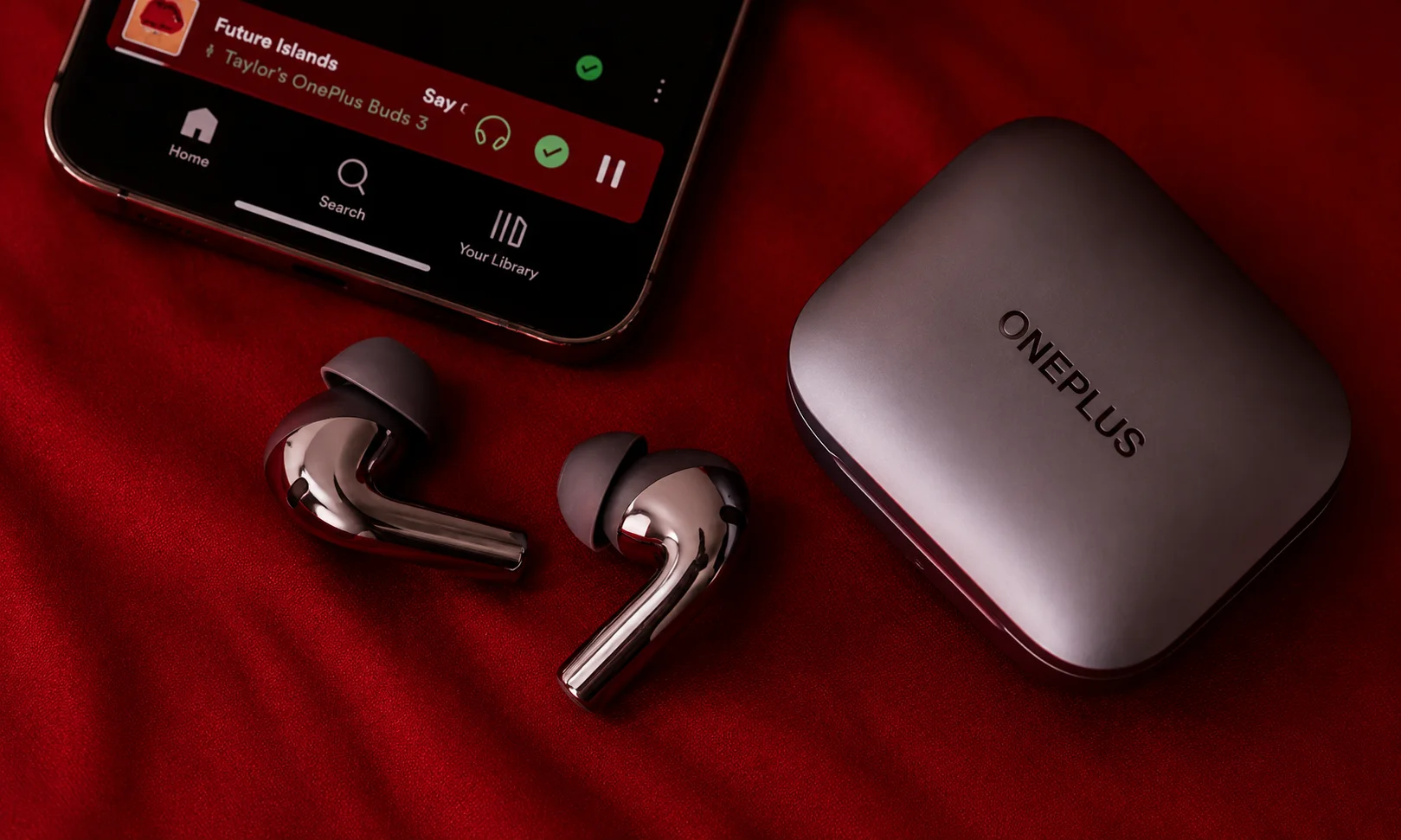 OnePlus earbuds and charging case resting on a warm-toned background.