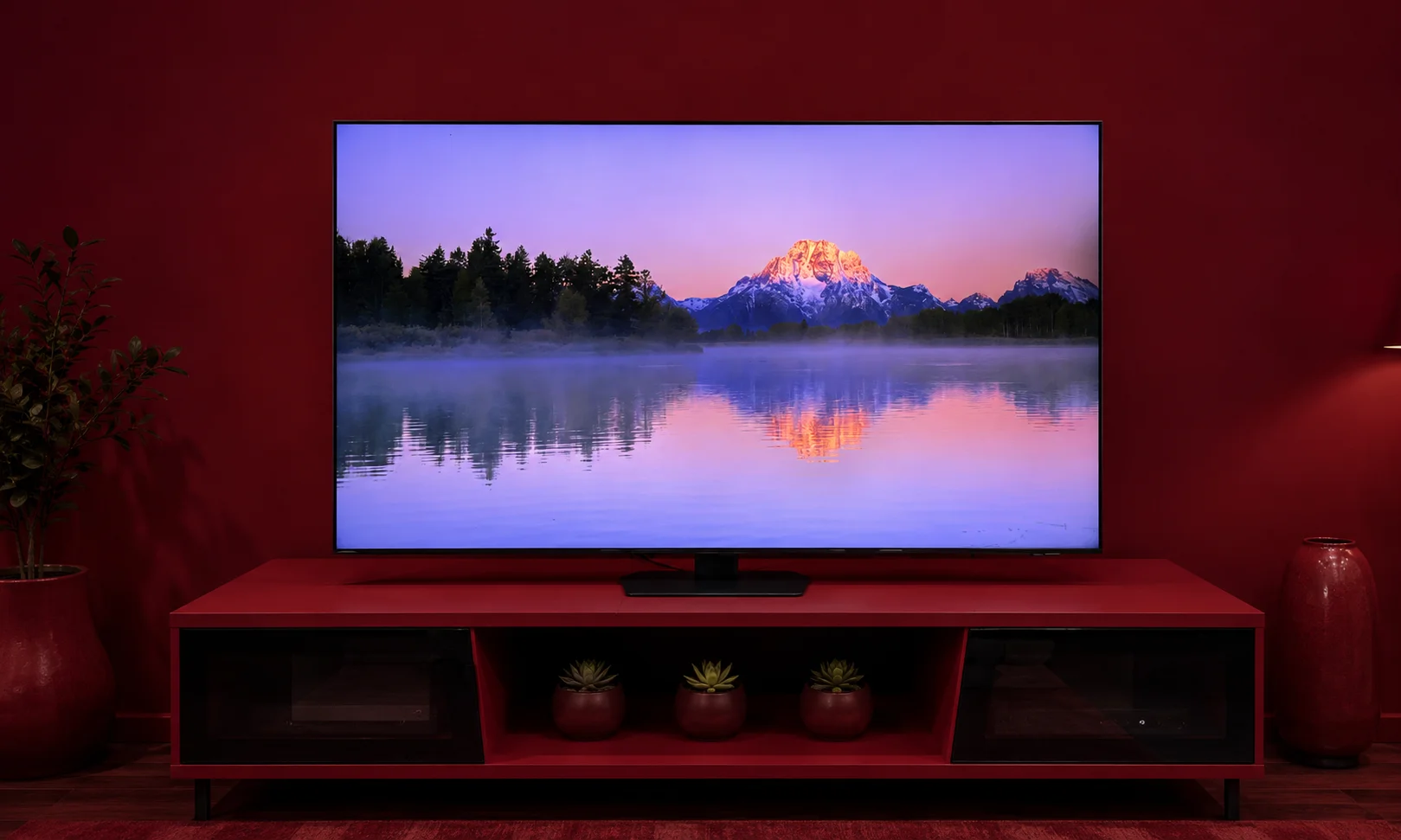 A Samsung QN90F TV set against a dark red environment.