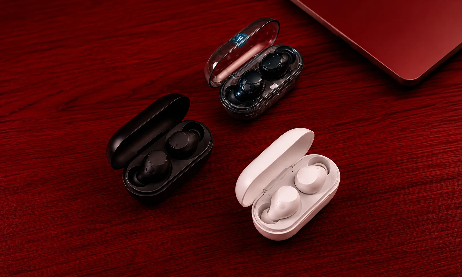 Sony WF-1000XM5 earbuds and charging case displayed on a red surface.