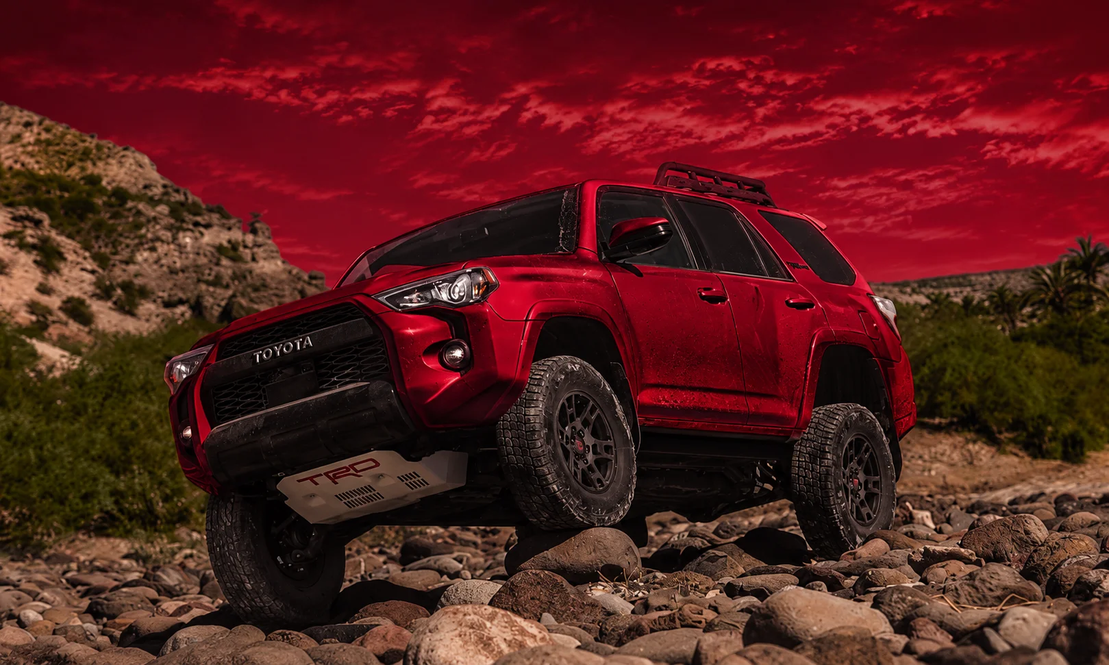 | 2026 Toyota Trucks: Tacoma vs Tundra Specs, Prices, Reliability; What’s New Red TRD Sport truck on rocky trail with red ambient lighting