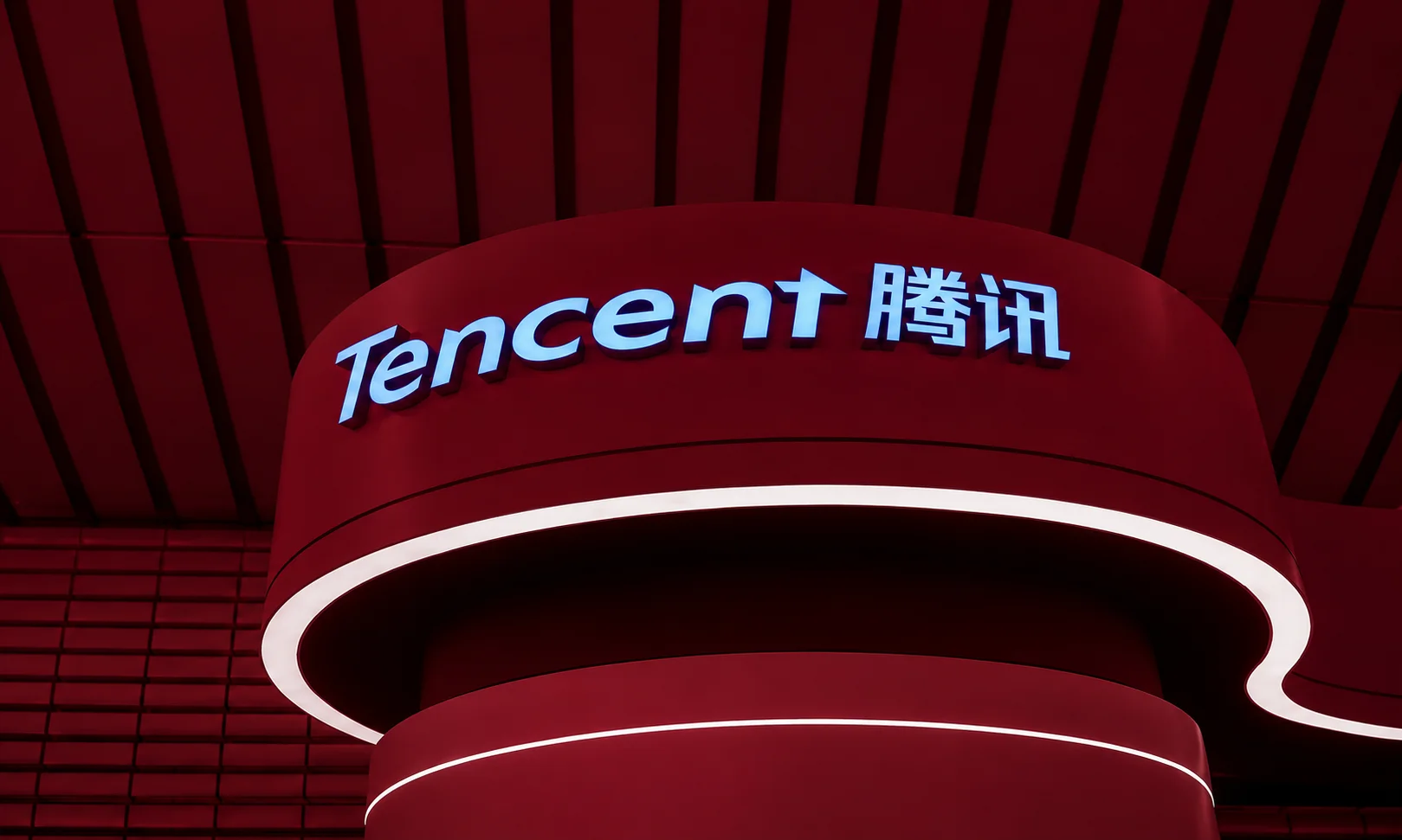 A graphic featuring the Tencent branding displayed in a corporate red-toned setting.