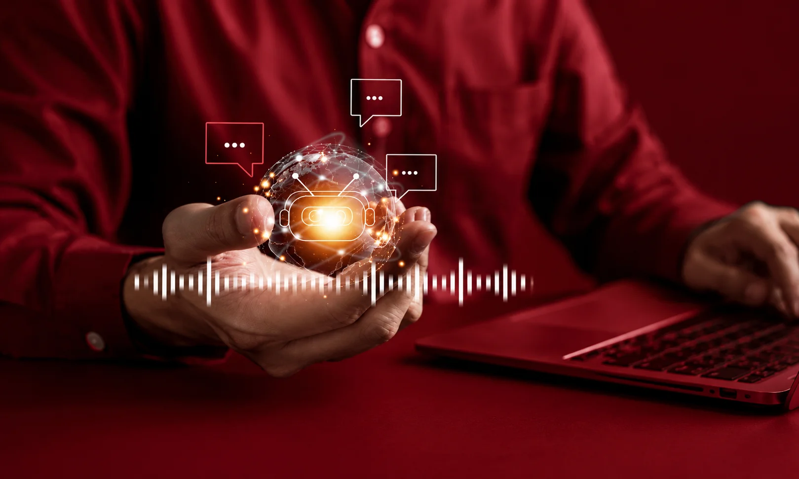 Person holding a glowing digital globe with AI chat bubbles and audio wave graphics while working on a laptop