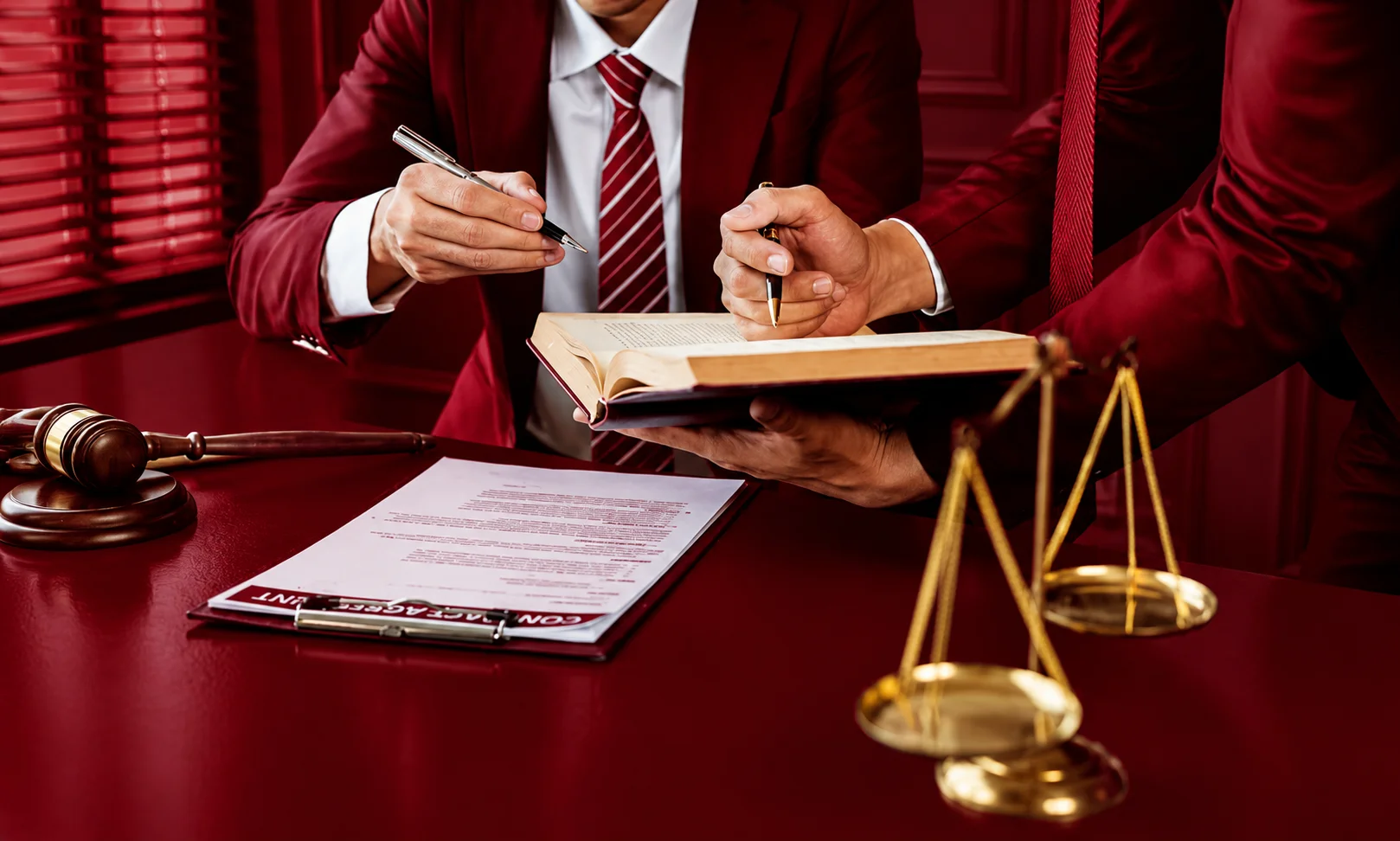Lawyers signing legal agreements and reviewing documentation during a settlement process.