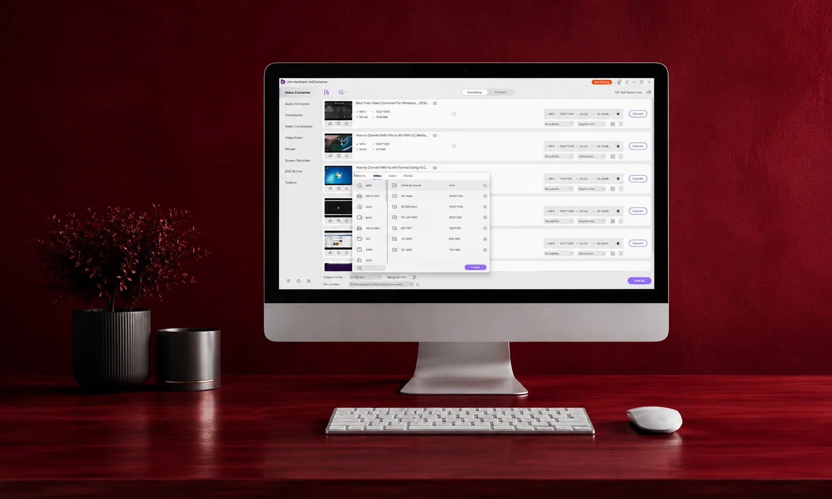 Desktop computer setup displaying software interface on a rich red desk