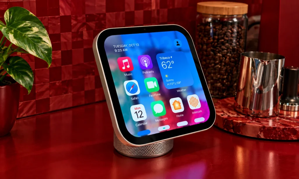 Apple HomeView touchscreen with music, weather, calendar, and smart home apps displayed on a tabletop stand in a modern kitchen.