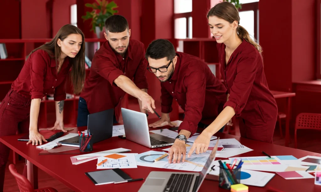 Supplier funded marketing strategy discussed by a team reviewing campaign plans, sales charts, and promotional materials.